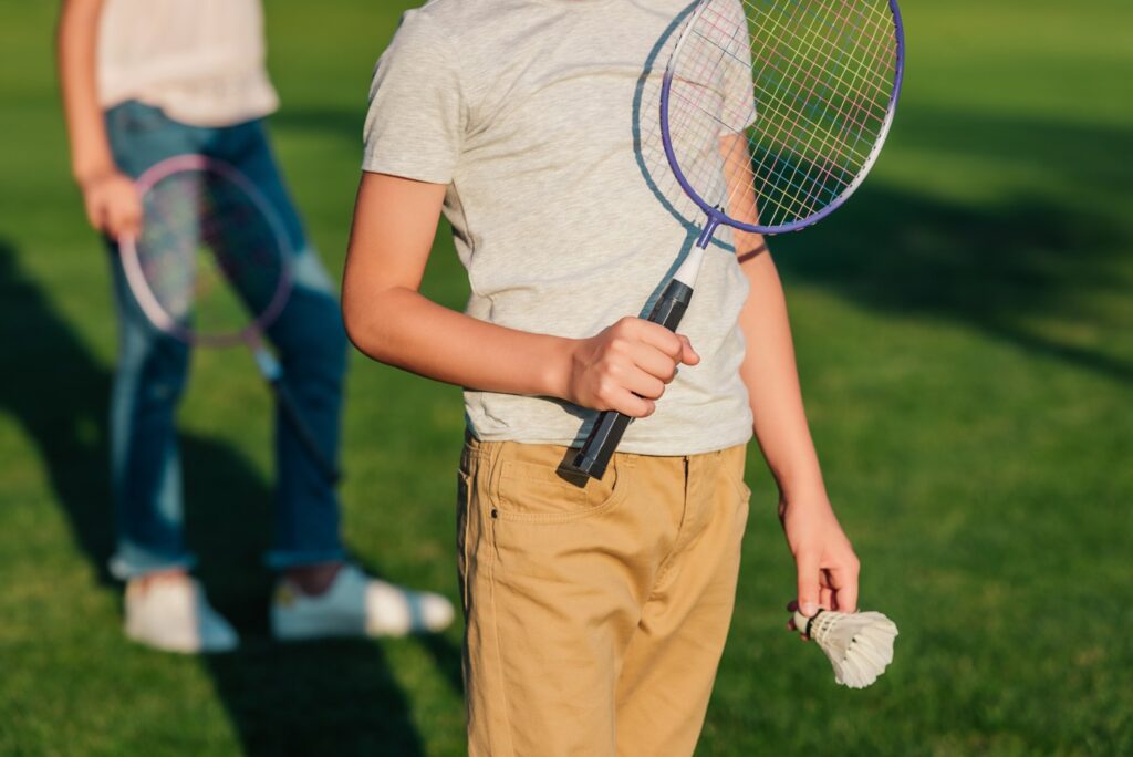 partial-view-of-child-holding-badminton-racket-and-2023-11-27-05-35-25-utc